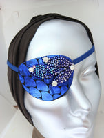 Women's high-fashion eye patch "MIDNIGHT MADNESS" is expertly handmade with blue metallic fabric overlaid with sequin fabric and adorned with 4 pearls. A matching elastic band and a soft backing of recycled fabric provide comfort. An exciting design that
