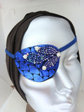 Women's high-fashion eye patch "MIDNIGHT MADNESS" is expertly handmade with blue metallic fabric overlaid with sequin fabric and adorned with 4 pearls. A matching elastic band and a soft backing of recycled fabric provide comfort. An exciting design that